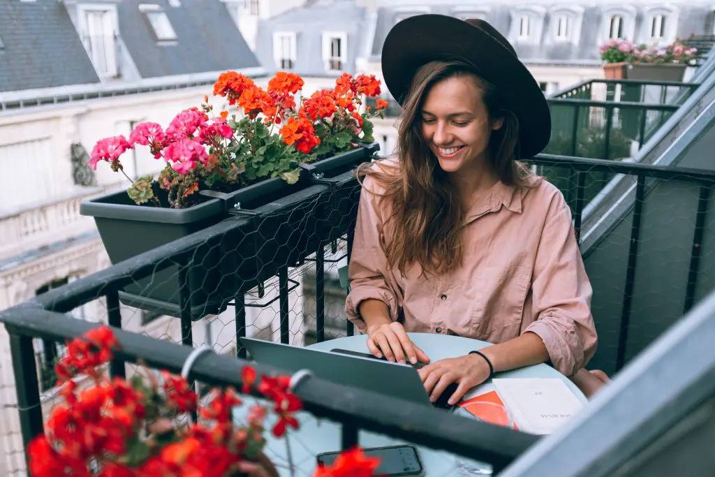 young woman working on laptop on balcony